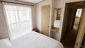 Hotellihuone, jossa on sänky, vaatekaappi, kylpyhuone ja näkymä ulos.