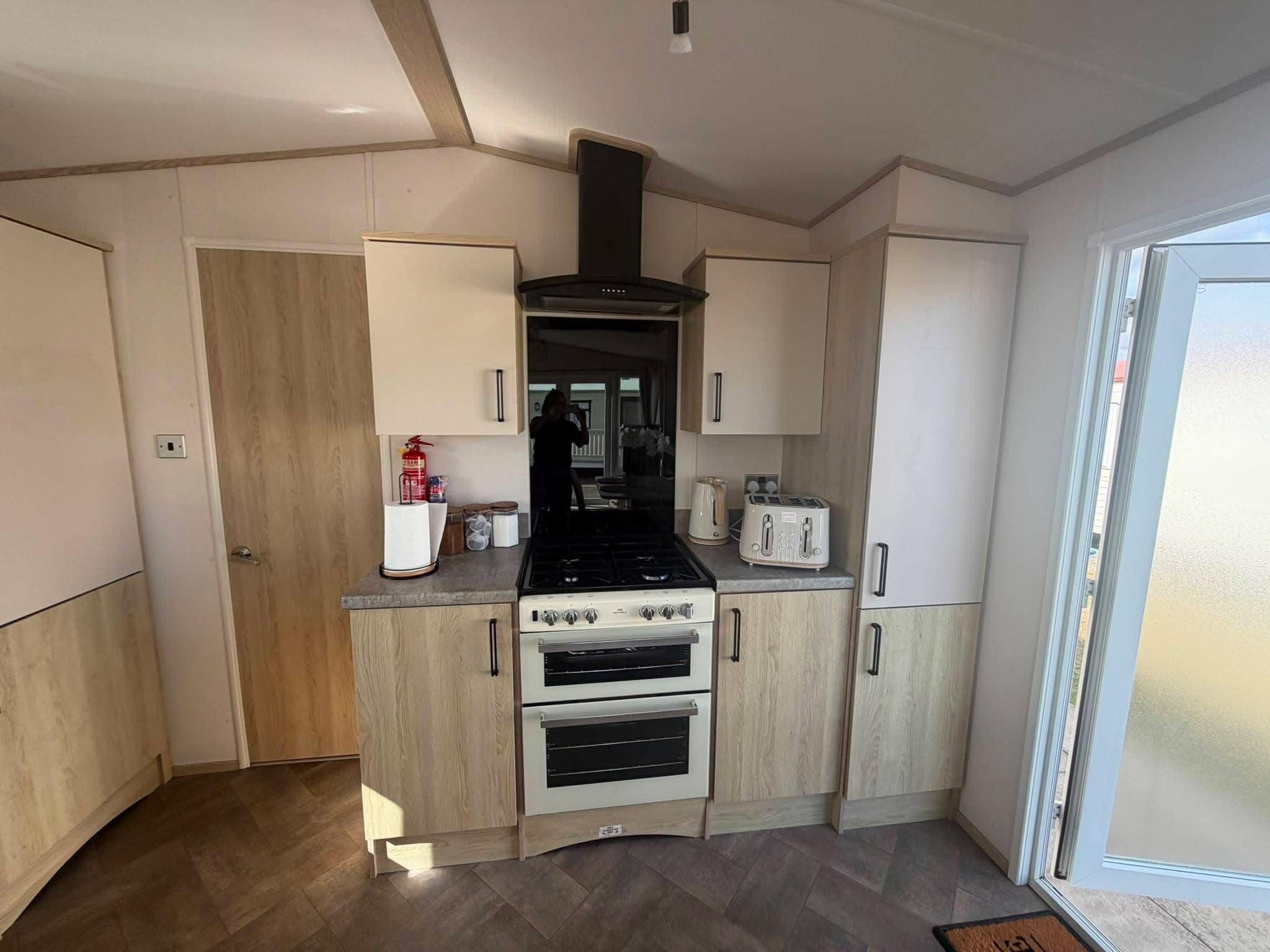 A compact kitchen with a gas stove, oven, and a toaster.