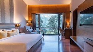 Habitació d'hotel moderna amb un llit gran, una taula de treball, una cadira i una televisió.
