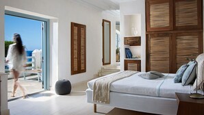 A bedroom with a large bed, wooden headboard, and a view of the outdoors. - Belvedere Waterfront Villa and Suites (Mykonos)