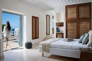 Ein Schlafzimmer mit einem großen Bett, einem Holz-Kopfteil und Blick ins Freie.