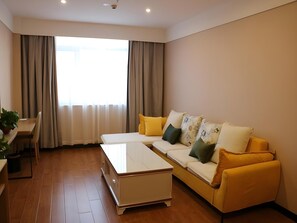 Una sala de estar moderna con un sofá, una mesa de centro y un comedor con una mesa y sillas.