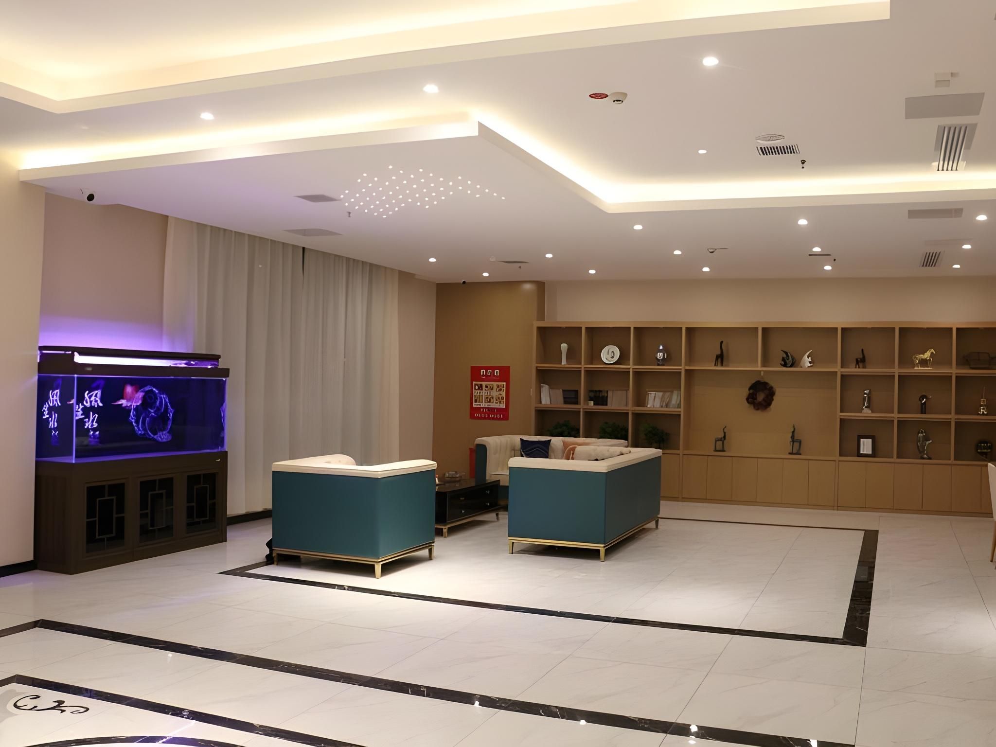 A modern living room with a flat-screen TV, two sofas, a coffee table, and a bookshelf.