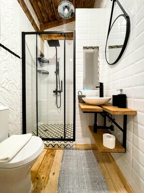A modern bathroom with a glass-enclosed shower, a wooden vanity, and a white tiled wall. - Oasis Resort & Spa, Lozenets (Tsarevo)