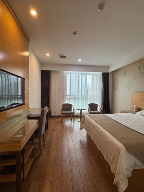 A hotel room with a bed, a desk, two chairs, a TV, and a window with curtains. - Greentree Inn Hefei Changfeng County Gangji Town Jingang Avenue Express Hotel (Hefei)