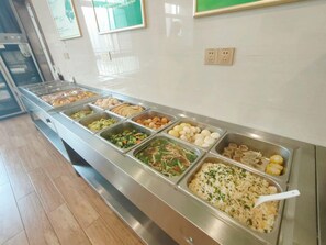 Una barra de buffet con diversas opciones de comida.