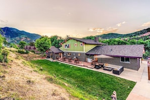A residential property with a spacious patio, a large lawn, and a mountain backdrop. - Innhale Cannabis Friendly B&B - Adults Only (Manitou Springs)