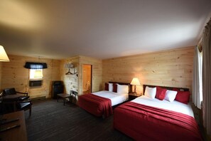 A hotel room with two beds, a desk, a chair, a TV, and a lamp. - The Welcome Inn (Mackinaw City)