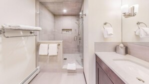 A modern bathroom with a glass-enclosed shower, a vanity with a mirror, and a towel rack. - Willows, a Destination by Hyatt Residence (Snowmass Village)