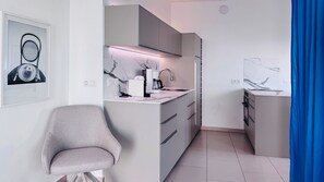 A compact kitchen with a modern design, featuring a built-in oven, a sink, and a coffee maker. - Refugio Cerro Gordo Studio 1: A Dream Castle (La Herradura)