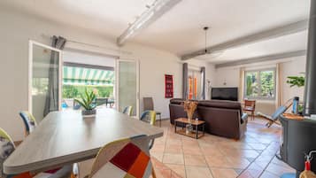 Un grand espace de vie comprenant une table à manger, un canapé et un téléviseur.