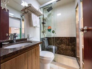 A bathroom with a glass shower enclosure, a white toilet, and a marble-tiled wall. - Greentree Inn Suzhou Wujiang Yongkang Pedestrian Road Hotel (Suzhou)