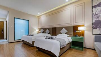 Habitación de hotel con dos camas, una mesita de noche verde, una lámpara de pared y un ventanal grande.