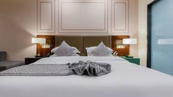 A hotel room with a large bed, two bedside tables with lamps, a headboard, and a window.