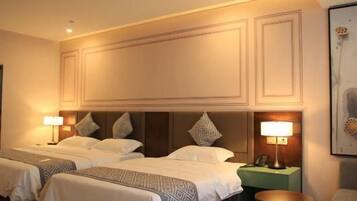Een hotelkamer met twee bedden, nachtkastjes, lampen en een lijst met een afbeelding aan de muur.