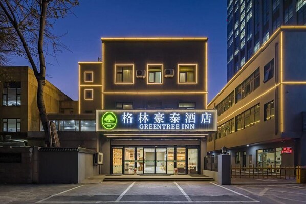 Ein Hotel mit moderner Fassade, beleuchteter Beschilderung und einem verschlossenen Eingang.