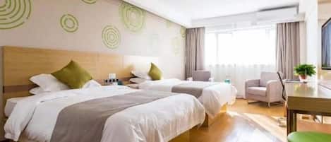 A hotel room with two beds, a desk, a chair, and a large window.