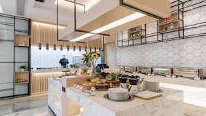 A modern kitchen with a marble countertop, a chef preparing food, and a hexagonal patterned wall. - Yaduo Hotel, Dongshahu, Suzhou Industrial Park (Suzhou)