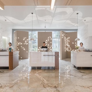 A modern reception area with a marble floor, a central desk, and decorative lighting. - Yaduo Hotel, Dongshahu, Suzhou Industrial Park (Suzhou)