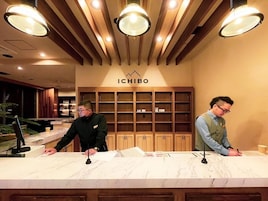 A reception desk with a wooden backdrop and a sign that reads 'ICHIBO'.
