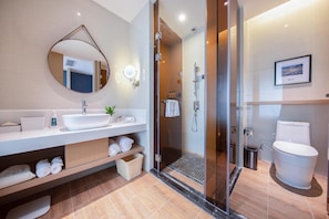 A modern bathroom with a glass-enclosed shower, a large mirror, and a white sink. - Atour Hotel (Kunming)