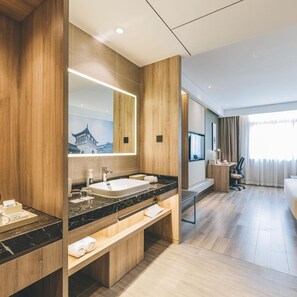 A modern hotel bathroom with a large mirror, a sink, and a vanity. - Atour Hotel (Jiaxing)