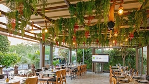 An indoor restaurant with wooden tables and chairs, hanging plants, and a sign for 'CITCUS Restaurant'. - Theluna Suite Hotel (Konyaalti)