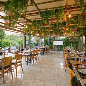 An indoor restaurant with wooden tables and chairs, hanging plants, and a sign for 'CITCUS Restaurant'. - Theluna Suite Hotel (Konyaalti)