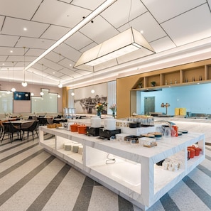 A modern kitchen with a marble countertop, a coffee station, and a view of a cityscape through the window. - Atour Hotel Wangting Suzhou (Suzhou)