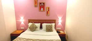 A hotel room with a bed, two bedside tables, and wall-mounted lamps. - Hotel Silver Retreat (Gandhinagar Gujrat)