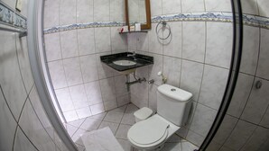 A bathroom with a toilet, sink, and mirror. - Pousada Sol e Mar - Noronha (Fernando de Noronha)