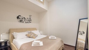 A hotel room with a bed, a bedside table, a mirror, and artwork on the wall. - Art Gallery Apartment in Florence (Florence)