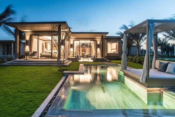 Uma casa moderna com piscina, área de estar externa e interior bem iluminado.
