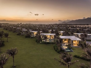 Um resort com várias villas, cada uma com piscina privativa e rodeada por vegetação exuberante.