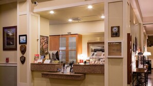 A reception area with a counter, framed pictures, and a plaque on the wall. - Resort At Port Ludlow (Port Ludlow)