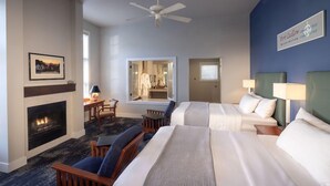 A hotel room with a fireplace, two beds, a ceiling fan, and a view of the city. - Resort At Port Ludlow (Port Ludlow)
