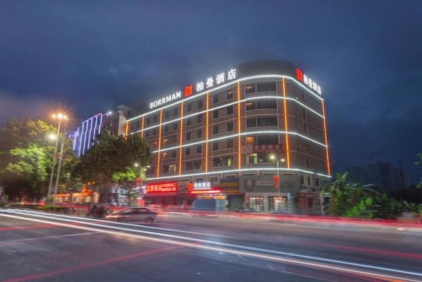 Un hôtel à plusieurs étages, doté d’une enseigne lumineuse et d’une architecture moderne.