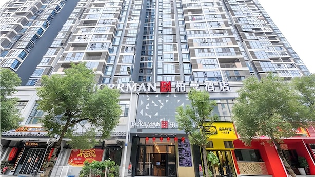 A high-rise building with multiple floors, featuring a prominent storefront with signage. - Borrman Hotel Hengyang Huaxin Caixia Street (Hengyang)