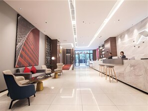 A modern hotel lobby with a reception desk, seating area, and a large abstract wall art piece. - Borrman Hotel Hengyang Huaxin Caixia Street (Hengyang)