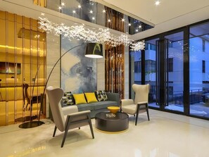 A modern interior with a sofa, chairs, a coffee table, and a large window offering a view. - City Comfort lnn Lijiang Transportation Station (Lijiang)