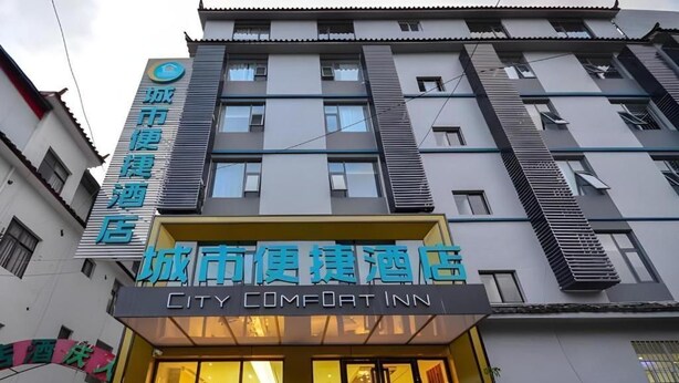 En bygning med et skilt for 'City Comfort Inn' og et andet skilt for 'City Hotel'.