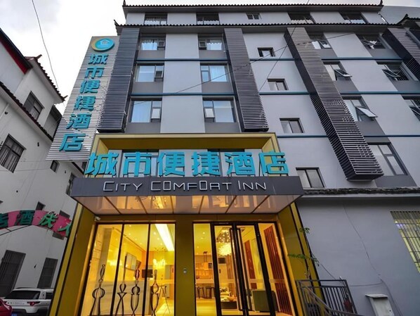 A building with a sign for 'City Comfort Inn' and another sign for 'City Hotel'. - City Comfort lnn Lijiang Transportation Station (Lijiang)