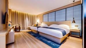 Een moderne hotelkamer met een groot bed, nachtkastjes, een bureau en een televisie.