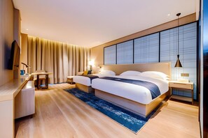 A modern hotel room with a large bed, bedside tables, a desk, and a television. - Echarm Hotel (Qianxinan Buyei and Miao)