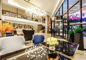 A modern lobby with a glass coffee table, seating area, and a staircase. - Echarm Hotel (Qianxinan Buyei and Miao)