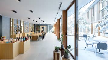 A modern interior with a reception desk, seating area, and large windows.