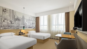 A hotel room with two beds, a desk, a chair, a TV, and a cityscape mural on the wall. - City Comfort Inn Enshi Jingang Baijia Plaza (Enshi)
