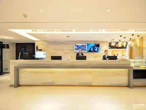 En reception med to skærme, et fladskærms-tv og et moderne interiør.