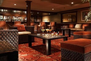 A bar area with wicker furniture, a patterned carpet, and a bar stocked with bottles. - JAZ Crown Jubilee Nile Cruise - Thursday VIA Luxor 7 & 4nts - Monday VIA Aswan 3nts (Luxor)