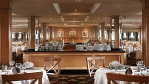 A spacious dining area with high ceilings, large windows, and a central bar. - JAZ Crown Jubilee Nile Cruise - Thursday VIA Luxor 7 & 4nts - Monday VIA Aswan 3nts (Luxor)